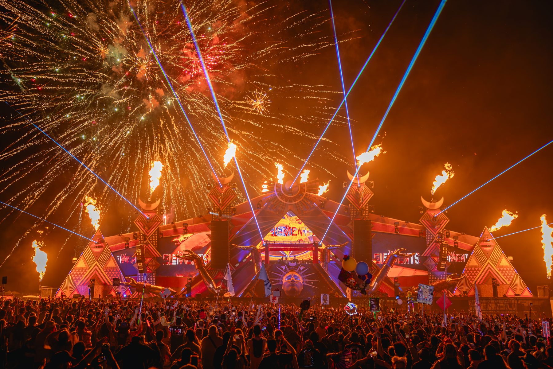 Festival main stage with flame effects, lasers and fireworks over the crowd